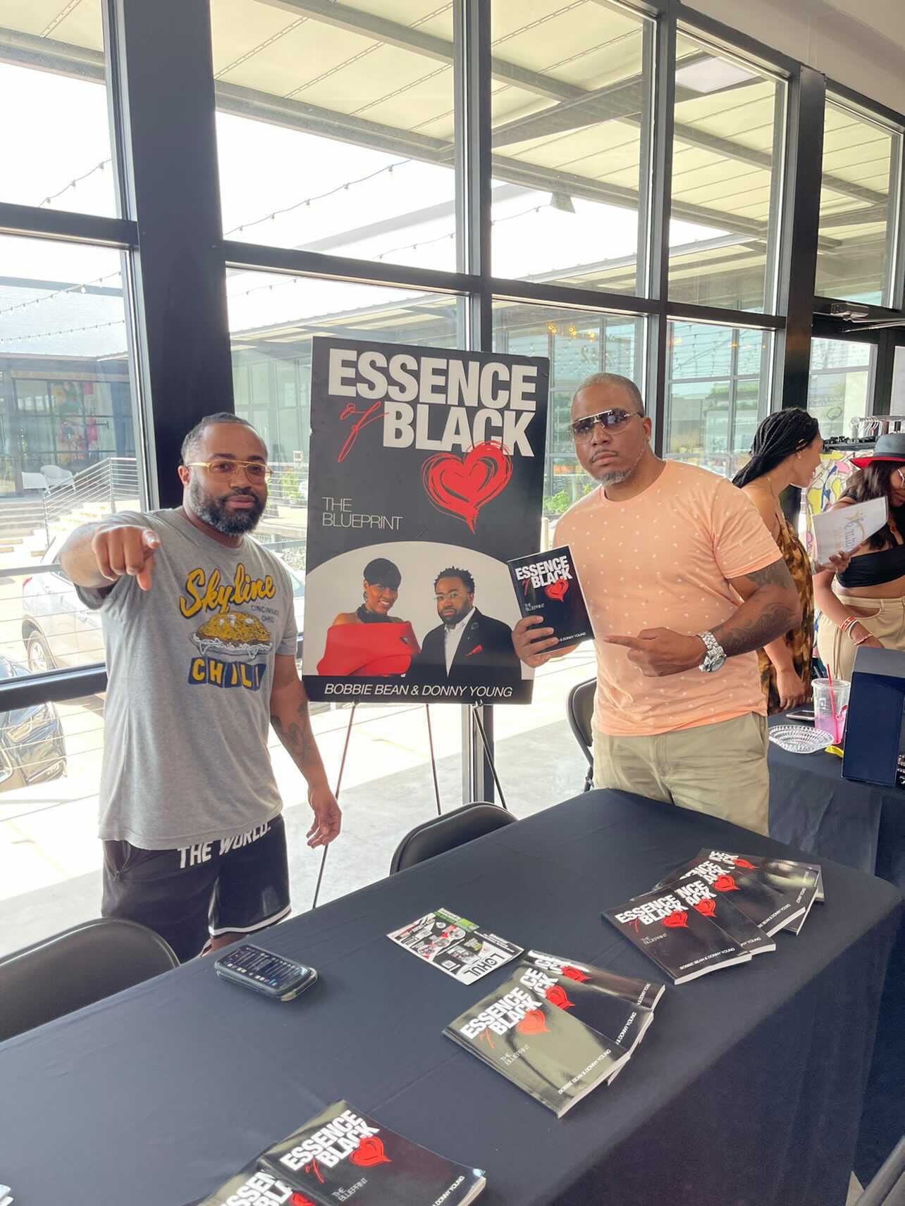 Jay.R Fogle with guests beside an Essence of Black Love display