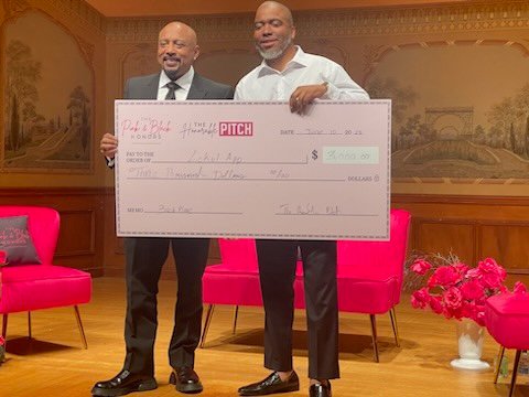 Jay.R Fogle on stage presenting an award check